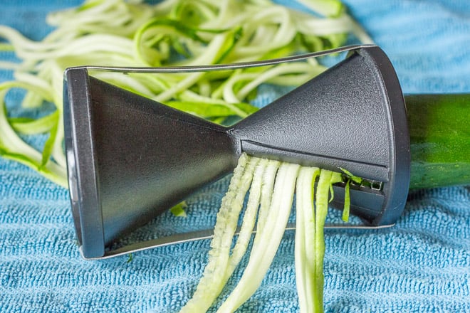 spiralizing zuchhini for zoodles on a blue towel