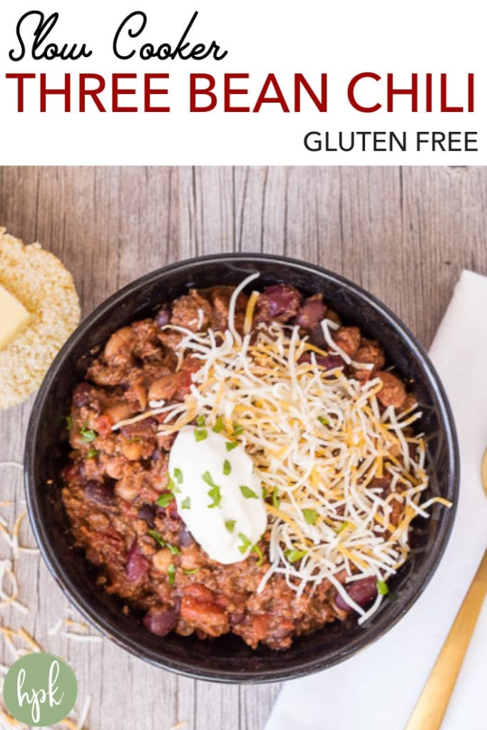 This Gluten Free Slow Cooker Three Bean Chili is an easy recipe for weeknight dinner. Cook up the ground beef, dump everything into the slow cooker, then let it cook until dinner time. Great for a crowd, or just a hungry family. Serve with cheese and sour cream, plus some cornbread on the side! #chili #glutenfree #crockpot #slowcooker #comfortfoods