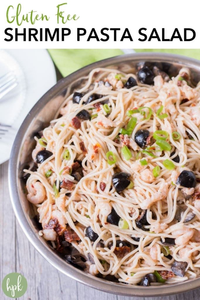 This Gluten Free Shrimp Pasta Salad recipe is a simple cold dish for a hot summer day. It's easy to make, with olives and sun dried tomatoes to give an extra punch of flavor. It's perfect for potlucks or BBQs and holds up for lunch leftovers the next day. #glutenfree #pasta
