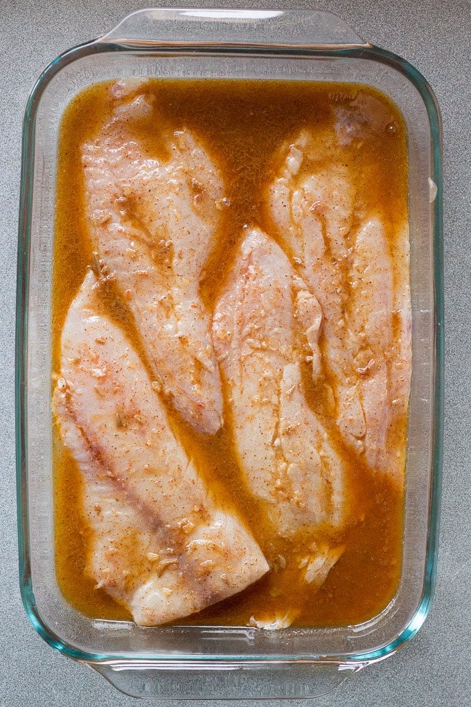 fish in glass dish marinating in easy fish taco marinade