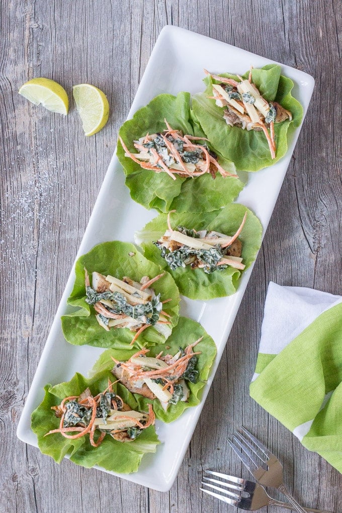 mini easy fish tacos on lettuce on a white rectangular platter
