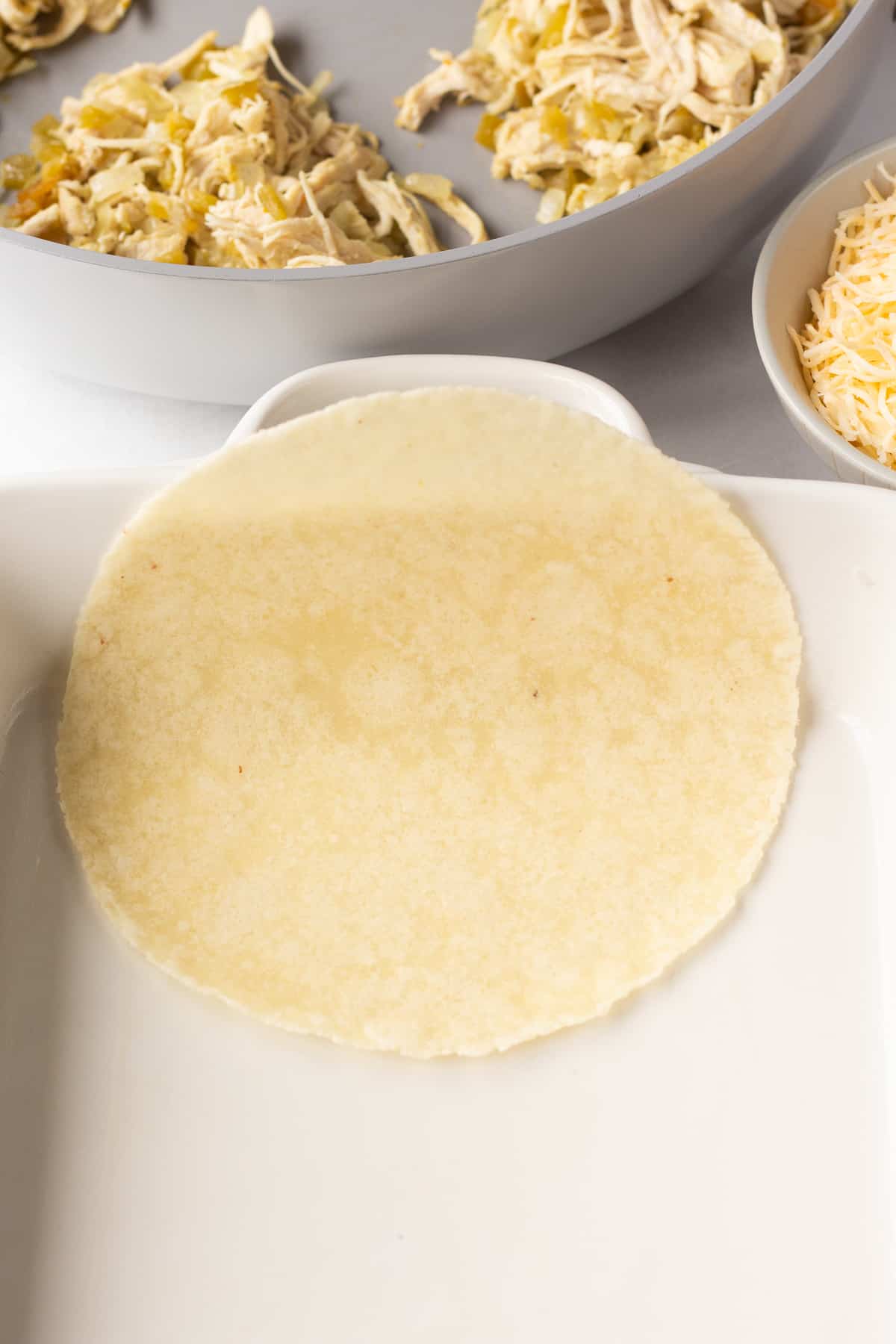 a paleo tortilla resting in one end of a white casserole dish.