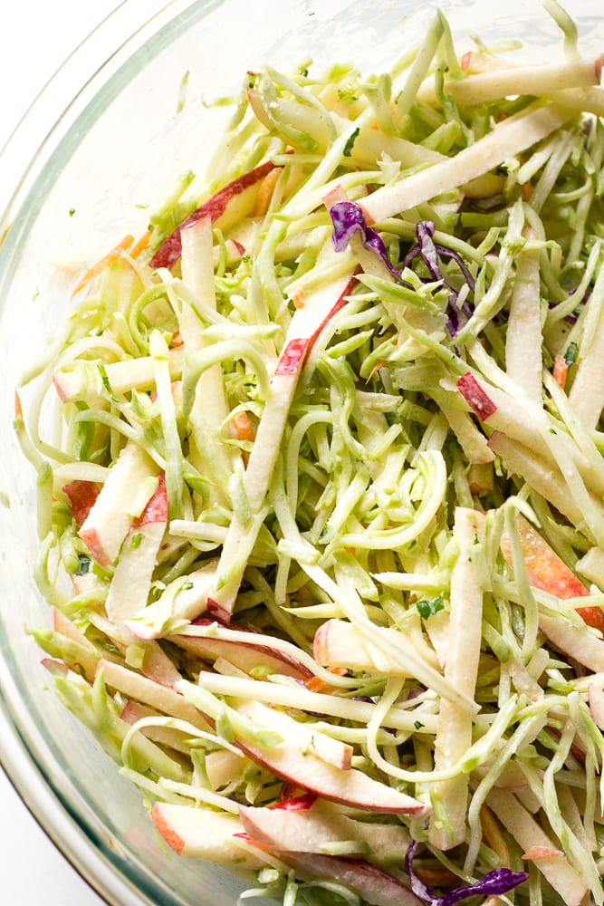 top down view of apple broccoli slaw in a glass bowl