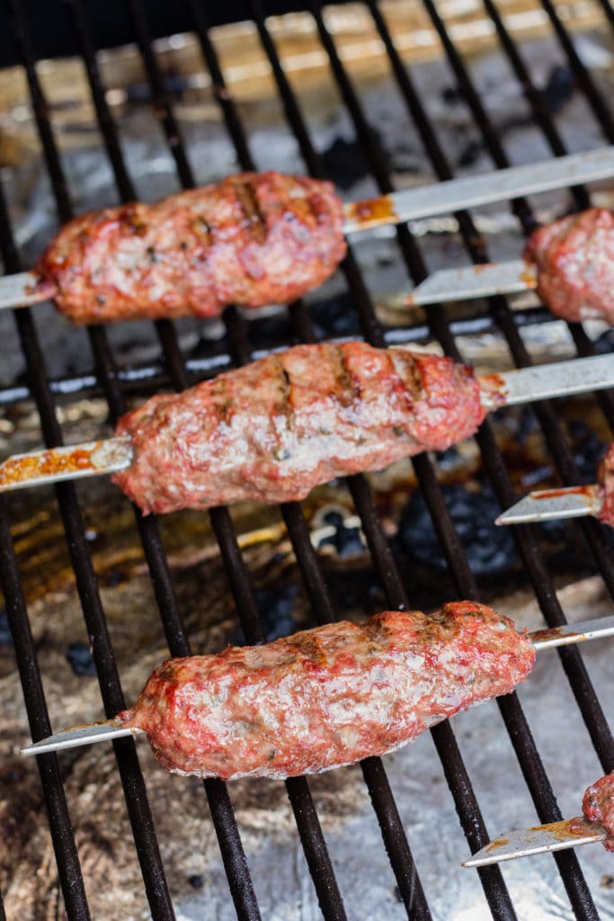 ground lamb kabobs cooking on a grill