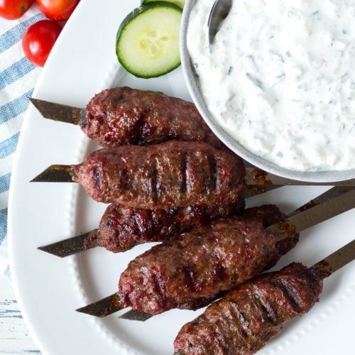 top down view of lamb skewers on white plate