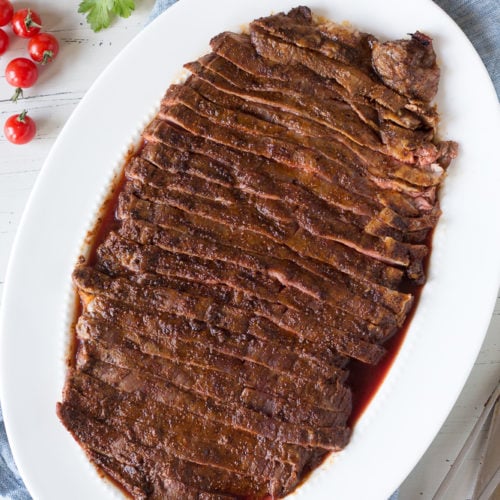cut flank steak on a white dish