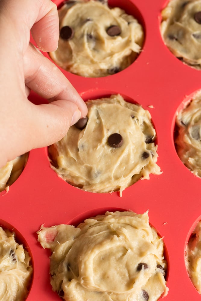 pushing chocolate chips into gluten free muffins