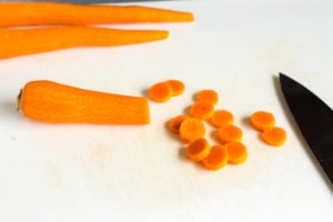 slicing carrots on a cutting board