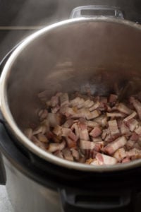 Bacon pieces starting to cook in an Instant Pot