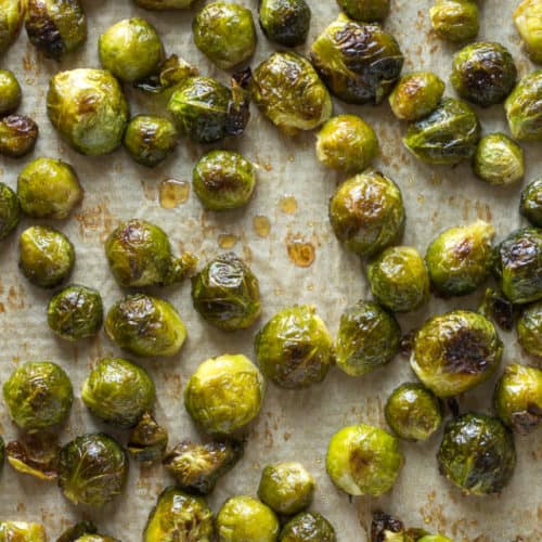 A top down shot of maple roasted brussels sprouts on a sheet pan.