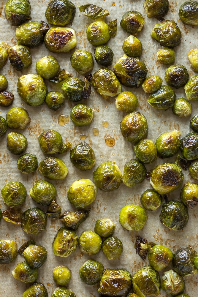 Top down shot of cooked maple roasted brussels sprouts on a sheet pan.
