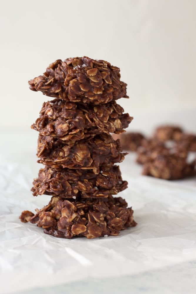 stack of no bake chocolate oatmeal peanut butter cookies on white parchment