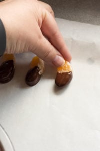placing chocolate covered orange on parchement