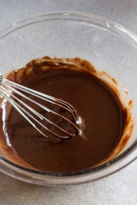 melted rum truffle mixture in a bowl with a whisk