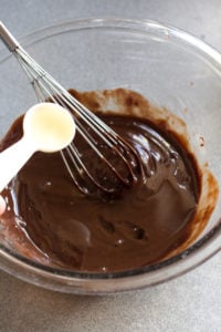 pouring rum into melted chocolate mixture