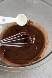 adding alcohol to chocolate mixture in bowl