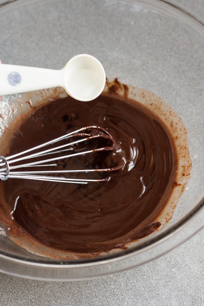 adding alcohol to chocolate mixture in bowl.
