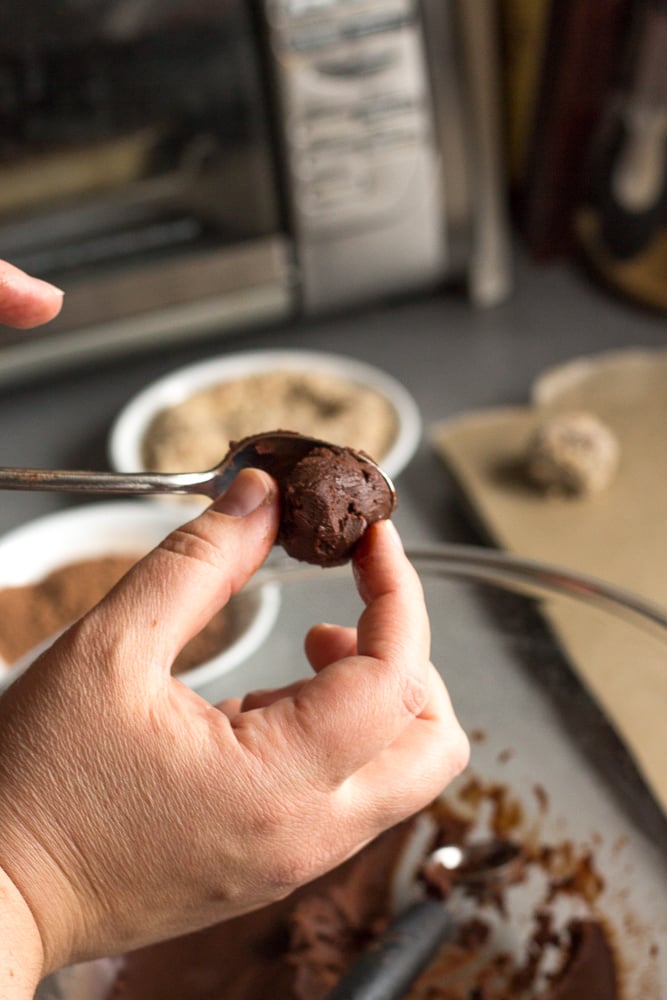 making a chocolate truffle ball by rolling chocolate out of a spoon.