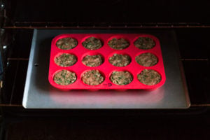 muffin tin with paleo meatloaf muffins going into oven