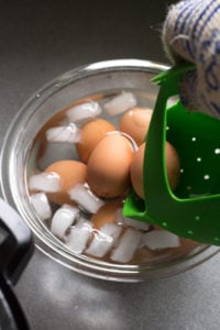 placing cooked eggs in ice bath
