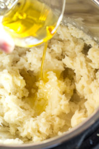 pouring ghee in whole30 mashed potatoes