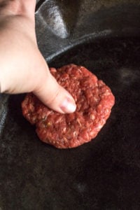 putting an indent in a slider patty in a skillet