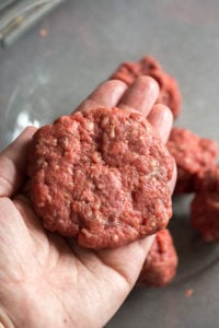 a slider patty held in a hand