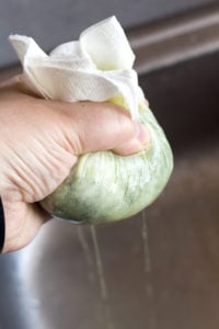 squeezing water out of spinach and onion with a paper towel by hand