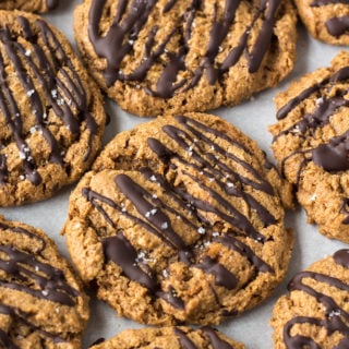 Top down shot of almond butter cookies with chocolate drizzle placed close together.