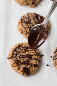 drizzling chocolate on paleo almond butter cookies