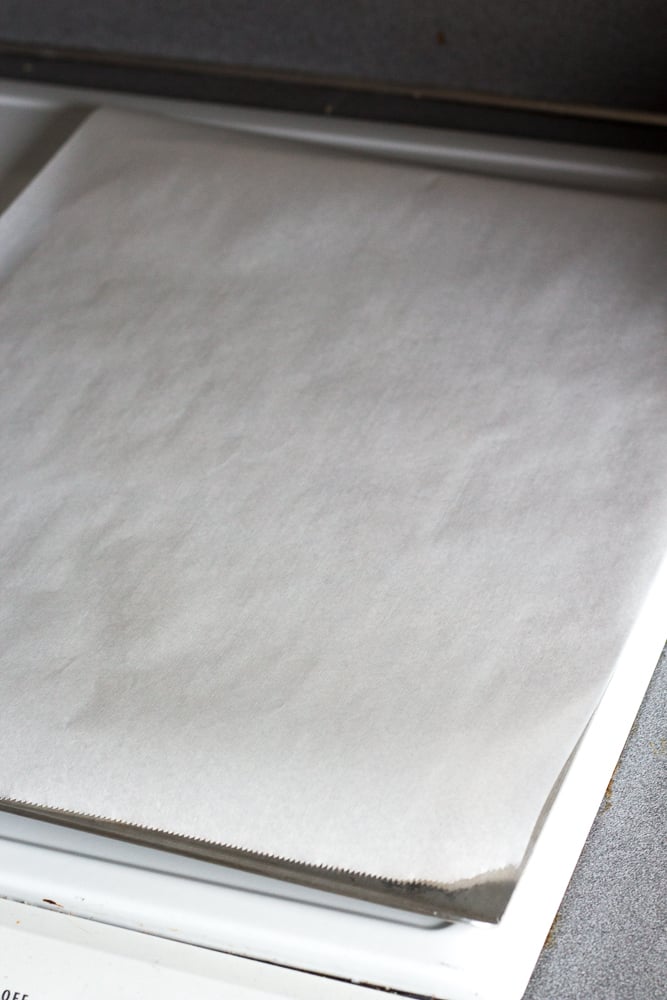 A cookie sheet with parchment paper on it.