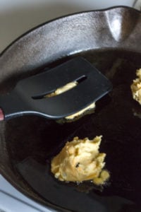 flattening potato mixture in the skillet with a spatula