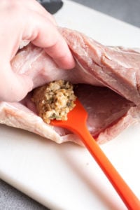 spreading stuffing into a pocket in a pork roast