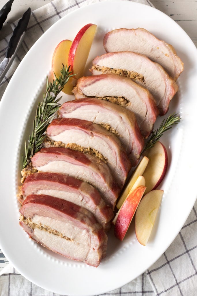 sliced smoked pork loin roast on a white platter