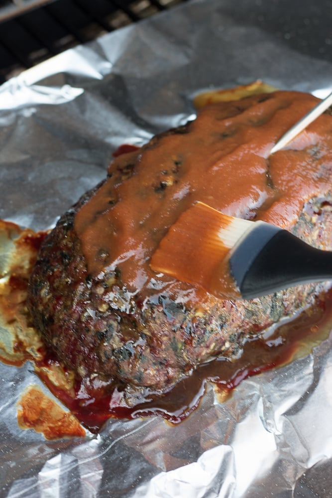 putting ketchup on a smoked meatloaf