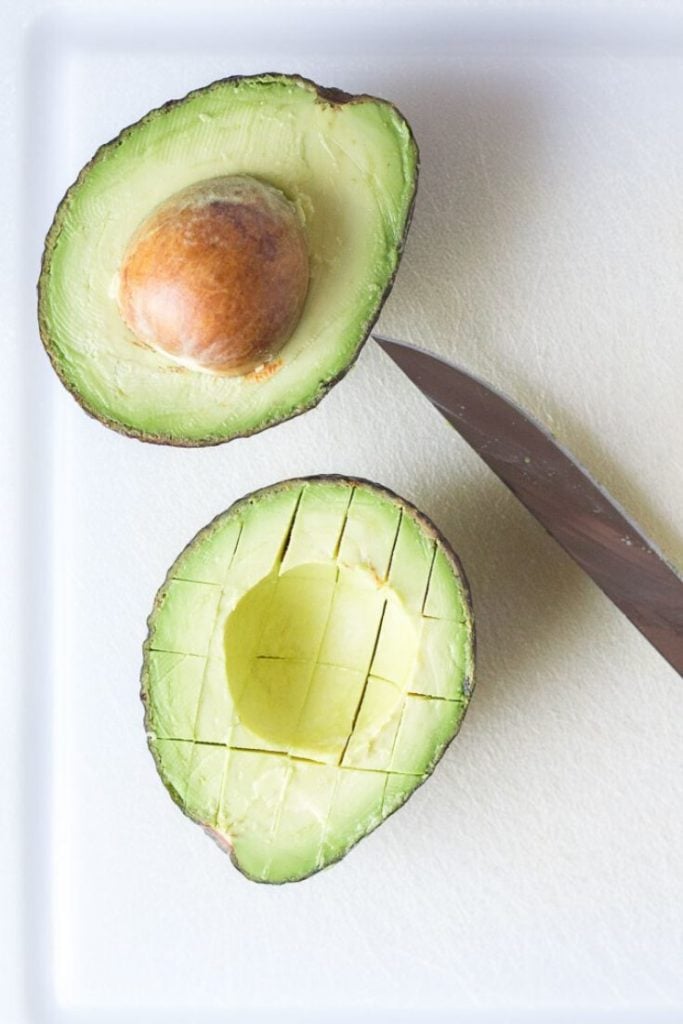cut avocado on a cutting board with a knife