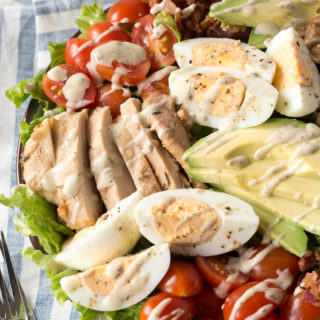 chicken cobb salad with dressing on a napkin