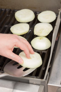 putting onion rings on a grill