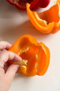 removing seeds from an orange bell pepper