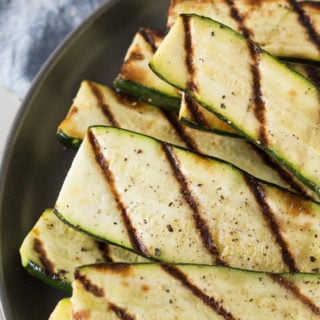 slices of grilled zucchini on a gray plate