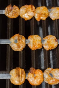 Close up of grilled shrimp skewers on a bbq.