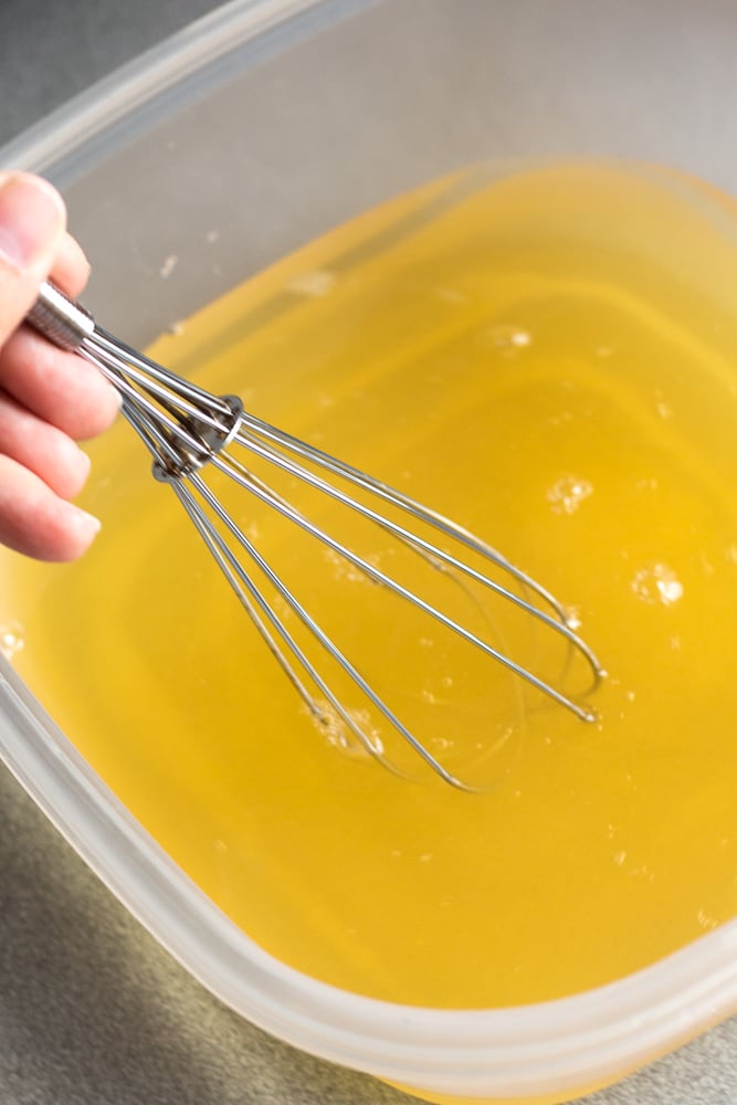 Stirring together an apple juice brine solution with a whisk.