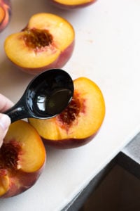 pouring oil over peach halves