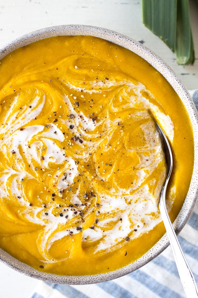 kabocha squash soup in a bowl with a spoon
