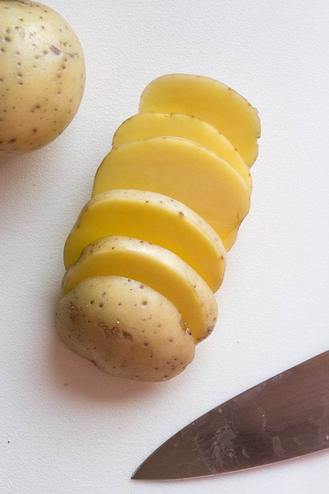 slices of yukon gold potatoes on a cutting board