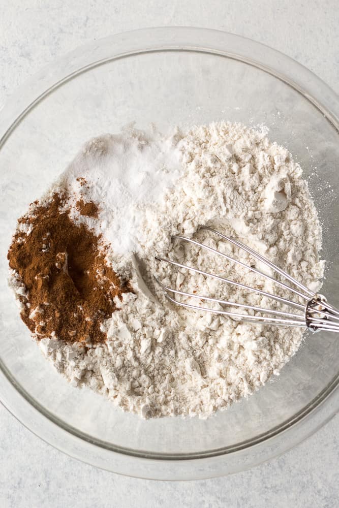 dry ingredients for apple muffins in a bowl with a whisk