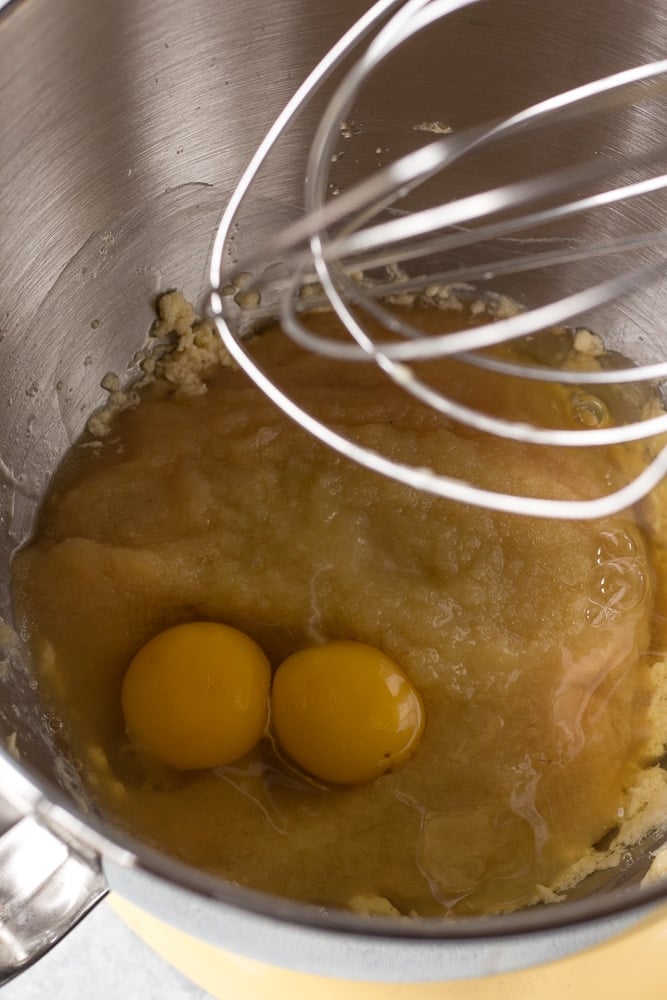 two eggs and other wet ingredients in the bowl of a stand mixer