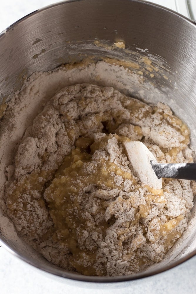 flour mixture being stirred into wet mixture for apple cinnamon muffins