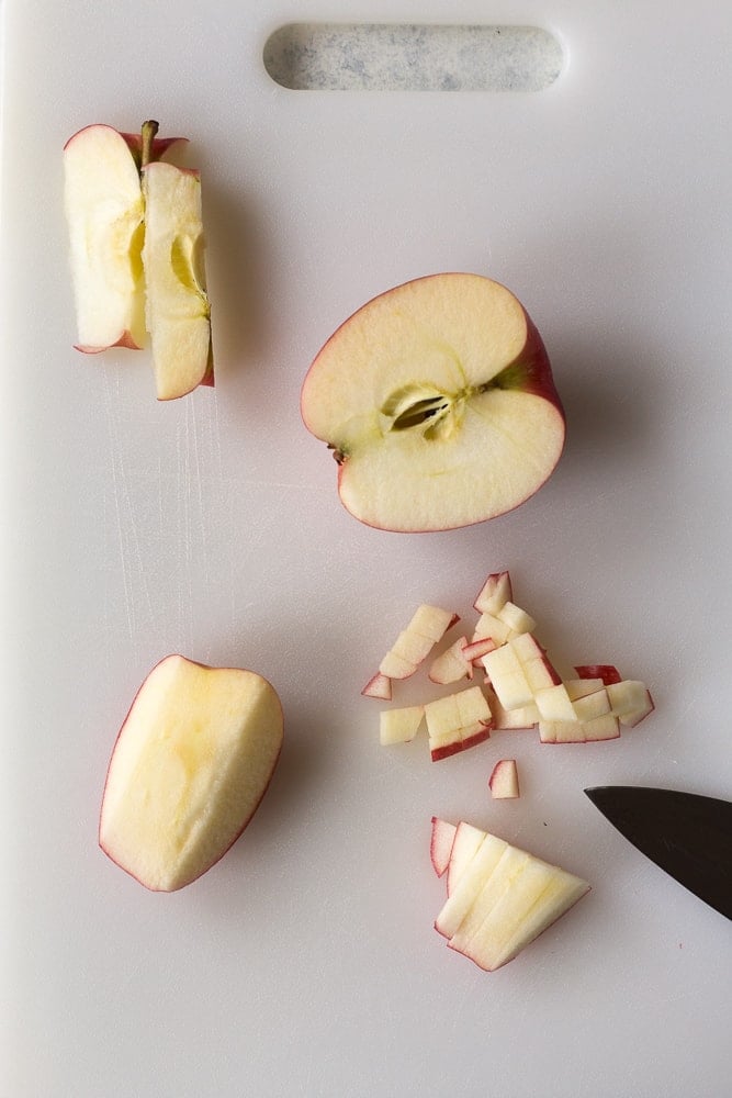 pieces of a cut up apple on a cutting board