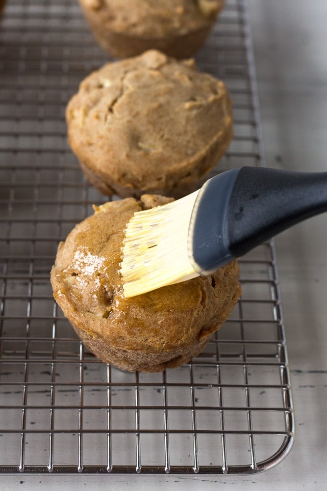 brushing butter onto the top of a muffin